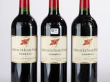 trois bouteilles de vin rouge posées côte à côte sur une table