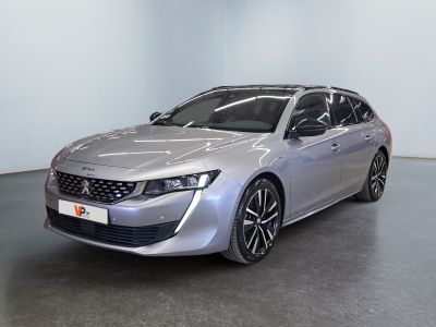 La voiture argentée est garée dans une grande pièce au sol noir