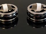 two rings that are sitting on a black surface