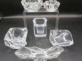 four pieces of glass on a table with a black background