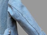 a man wearing a blue jacket and a tie on a gray background