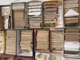several stacks of books are stacked on a shelf in a room