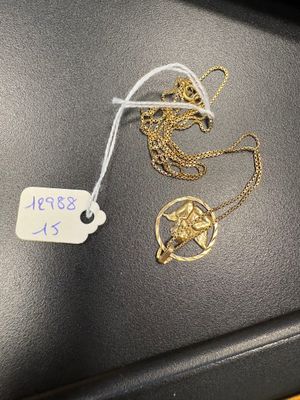 two gold necklaces on a black surface with a price tag