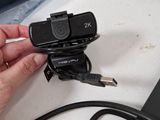 a person holding a camera that is plugged into a laptop