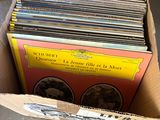une boîte remplie de disques posée par terre, à côté d'autres boîtes