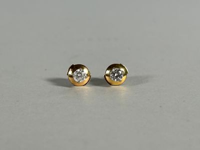 a pair of diamond stud earrings on a white surface
