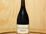 une bouteille de vin posée sur un tonneau en bois