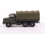 a toy army truck with a green cover on the back