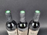three bottles of wine sitting on top of a table next to each other