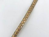 a close up of a gold colored metal object on a white surface