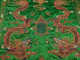 a close up of a green table cloth with a dragon design on it