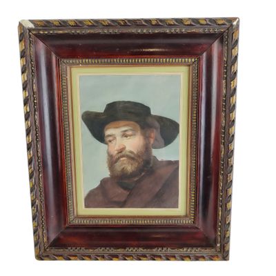 portrait d'un homme barbu coiffé d'un chapeau noir, dans un cadre en bois