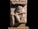 une image représentant une sculpture en pierre d'un homme tenant une bouteille