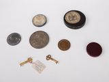 an assortment of coins, keys, and other items on a white surface