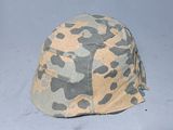 camouflage helmet on a gray surface with a white background