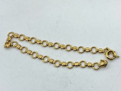 a close up of a gold chain on a white surface