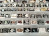 many different kinds of rocks on display in a display case