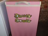 a pink and white refrigerator next to a white freezer