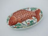 a plate with a fish on it on a white surface