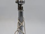 une image représentant une lampe argentée surmontée d'un abat-jour en verre