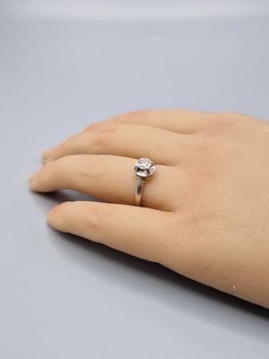 une main de femme portant une bague en diamant