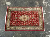 un tapis rouge et or posé sur un sol en béton