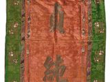 un tapis chinois orange et vert orné d'inscriptions orientales