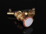 gros plan d'une paire de boucles d'oreilles sur une surface noire