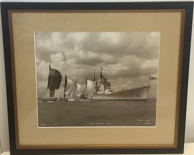 une vieille photo représentant un bateau sur l'eau, avec d'autres bateaux en arrière-plan