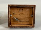 a small wooden box with a clock inside of it