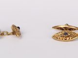 a pair of gold cufflinks with sapphire eyes
