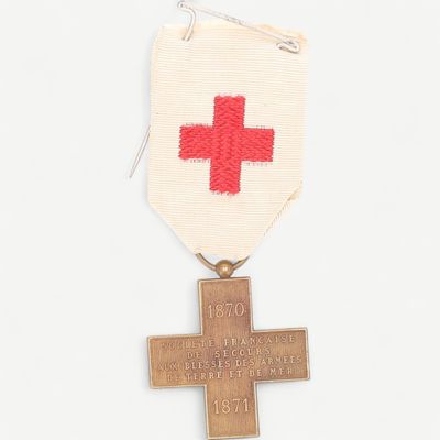 une médaille sur laquelle figurent une croix et une croix rouge