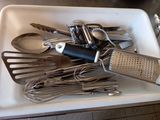 a lot of kitchen utensils in a white tray