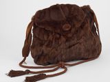 sac à main en fourrure marron orné de pompons sur fond blanc