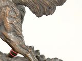 bronze statue of a dog on a rock with a red collar