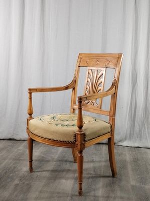 une chaise en bois avec une assise beige et un rideau blanc en arrière-plan