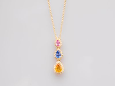 a yellow gold necklace with a multi colored stone pendant