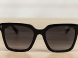a pair of black sunglasses sitting on top of a wooden table