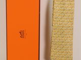 une boîte orange avec une cravate et une cravate jaune posées sur une table