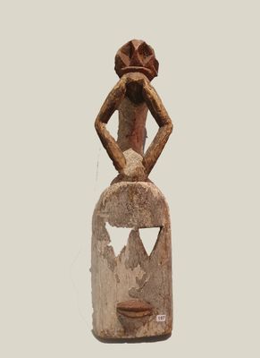 statue of a woman with a hat on her head sitting on top of a rock