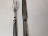 two forks and a knife on a white table