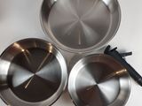 three stainless steel pans sitting on top of a white table