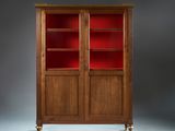 an antique mahogany bookcase with red glass doors and brass legs