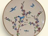 a decorative plate with birds and flowers on it