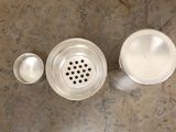 an overhead view of a kitchen sink with a strainer and a cup