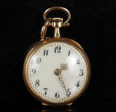 gros plan d'une montre de poche en or sur une surface noire