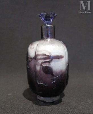 une petite bouteille en verre ornée d'un motif en noir et blanc