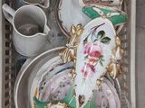 un plateau posé par terre, sur lequel se trouvent des assiettes et des tasses