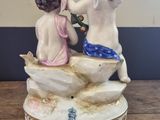 two figurines sitting on top of a wooden table