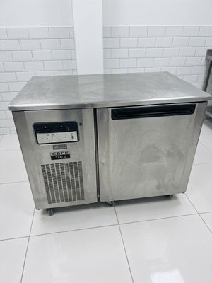 stainless steel counter top freezer in a commercial kitchen with tile flooring